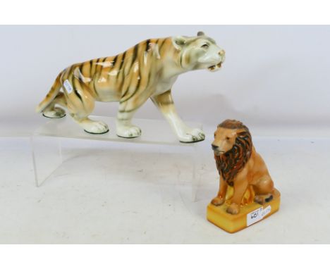 A Royal Dux study of a tiger, approximately 37 cm (l) and a limited edition Wade The British Lion figure. [2]. [W]