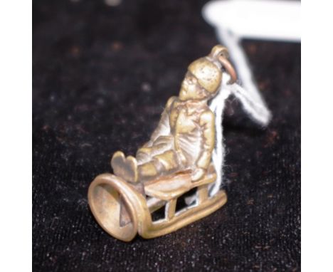 Rare vintage brass cigar cutter in form of seated man on a sled, of small proportions. (Height 3.5cm approx).