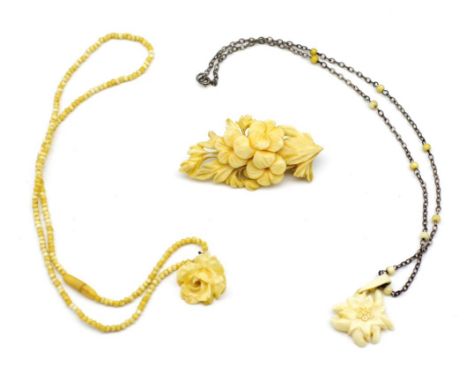 Carved Ivory jewellery group includes a well carved flower brooch, a beaded necklace and another pendant. This item may not b