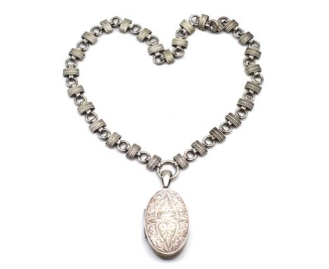 Antique silver locket and necklace marked silver to the bail. Locket has a hand engraved foliate and scroll work front panel.