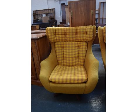 A Parker Knoll swivel armchair upholstered in mustard yellow and tartan button back fabric