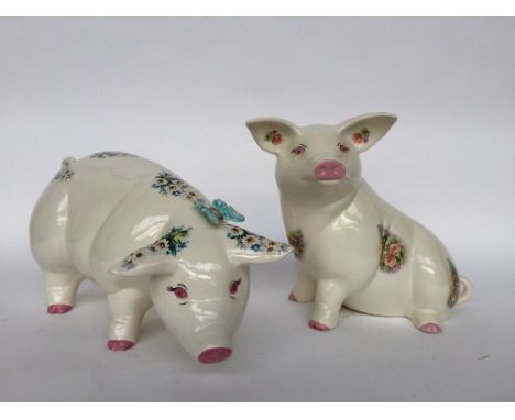 Two decorative ceramic pigs of floral design, one seated and marked M. Skillicorn to base and the other standing, 30cmH and 2