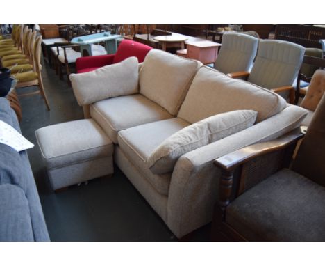 A two seater sofa upholstered in oatmeal fabric with matching throw cushions and a padded footstool on block feet 185cmW