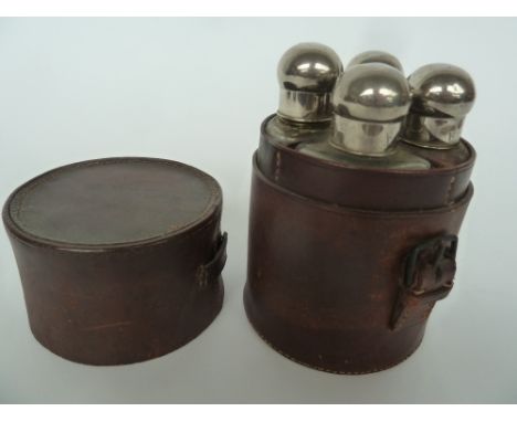 A Rider's Quartet Drinking Flask in a leather case, the four glass bottles with white metal screw caps, each bottle 13cm H wi