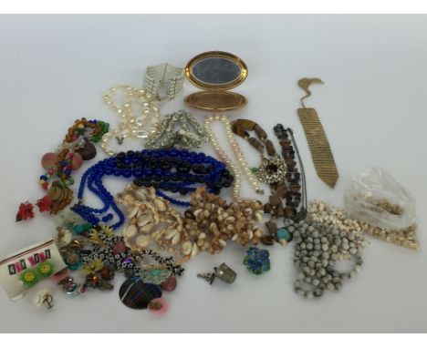 A selection of costume jewellery mainly necklaces, earrings, bracelets, charms, shell beads with a powder compact mirror and 