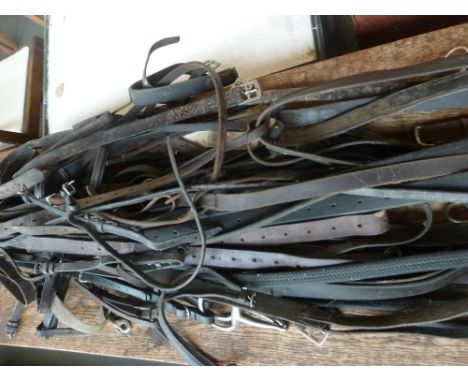 A large quantity of hunting tack to include reins, leathers, martingales, bridles and other items including a snaffle bit