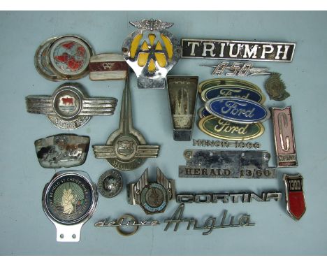 An AA badge no.4C90865 and a quantity of car badges, including Morris, Triumph, Austin etc.