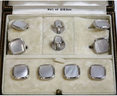 A cased Art Deco white gold mother-of-pearl dress stud set, with a cushion shaped pair of cufflinks, four buttons and two dre