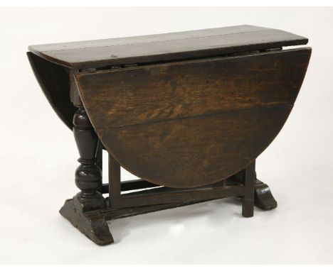 A 17th century and later oak oval gateleg table, with turned end standards, plain frame 'gate' supports and a flat stretcher,