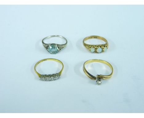 A gold five stone diamond ring, a single stone blue zirconia ring, an Edwardian three stone opal ring, and a single stone dia