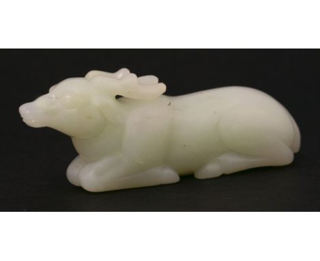 A 20th century jade stag, the pale-green stone carved as a recumbent antlered beast, 10.2cm