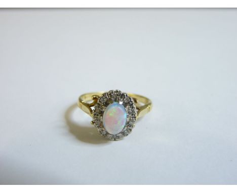 An 18ct gold opal and diamond oval cluster ring, finger size L