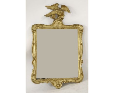 A gilt wall mirror, of shaped rectangular form with eagle surmount