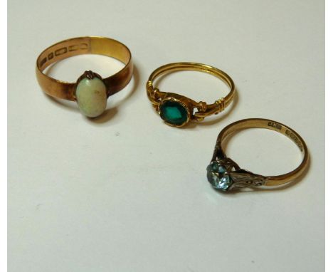 An 18ct gold green paste ring, a 9ct gold blue zircon single stone ring, and a 15ct gold band ring later set with an opal