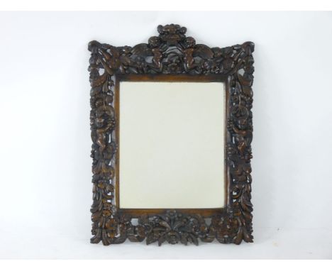 A Jacobean style wall mirror, carved with foliage and cherubs