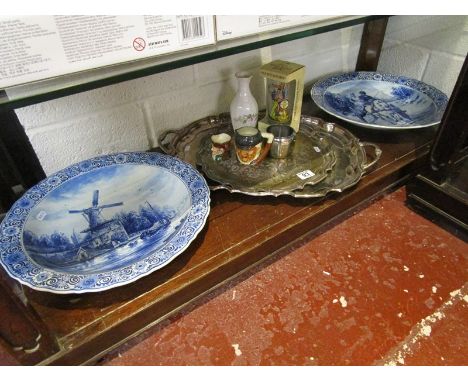 Shelf of collectables to include large pair of delft chargers, plated trays, Toby jugs etc