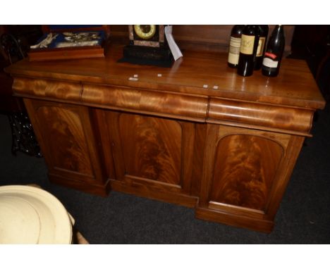 A Victorian mahogany breakfront sideboard, the rectangular top over three ogee moulded freeze drawers, three arched panel cup