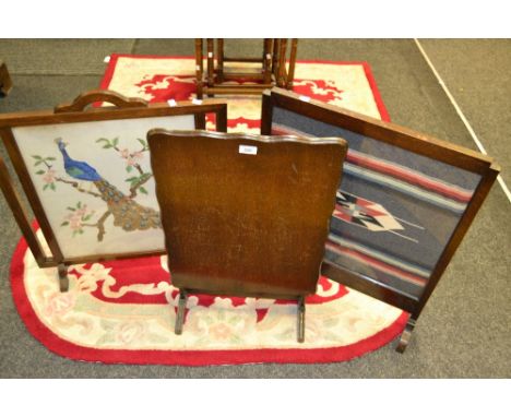 An early 20th Century mahogany firescreen the panel with woolwork design; others (3)