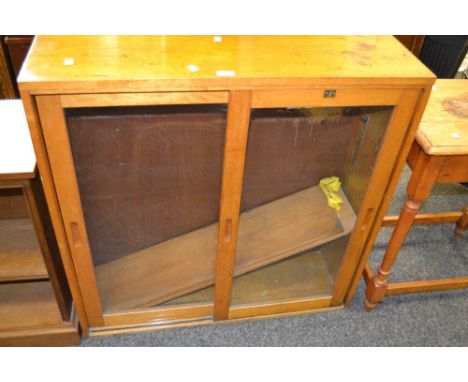 A mid 20th century light oak bookcase, sliding glass doors, c.1950