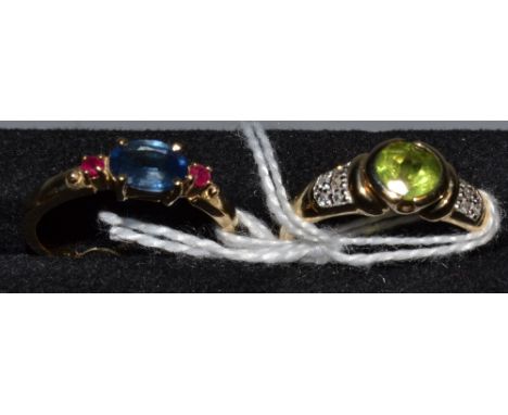 A 9ct gold lady's dress ring, set with a central peridot and diamond chips; another, set with aquamarine, ruby-type stones an