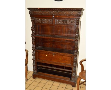 A VICTORIAN OAK OPEN BOOKCASE, with heavily carved masks, grapes and foliage, two drawers with lions mask handles above a sin