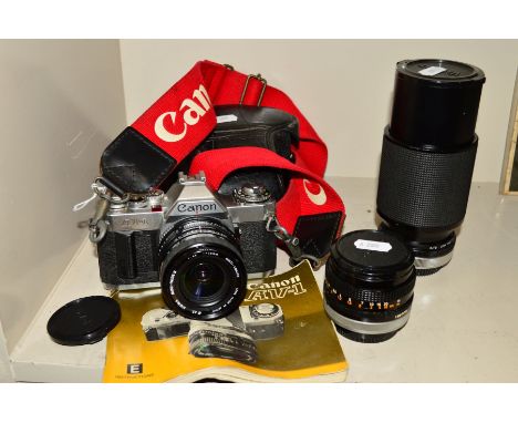 A CANON AV-1 FILM SLR CAMERA, fitted with a Sigma 28mm f2.8 lens, a Canon FD 50mm f1.8, a Vivitar 75-205mm f3.8 manual and le