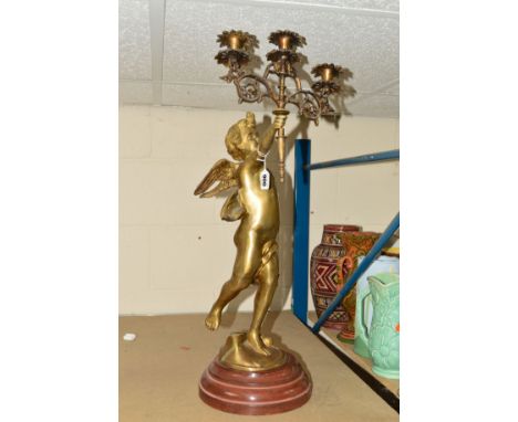 A LARGE BRASS CHERUB, holding a three light candelabra, on plinth, approximate total height 69cm