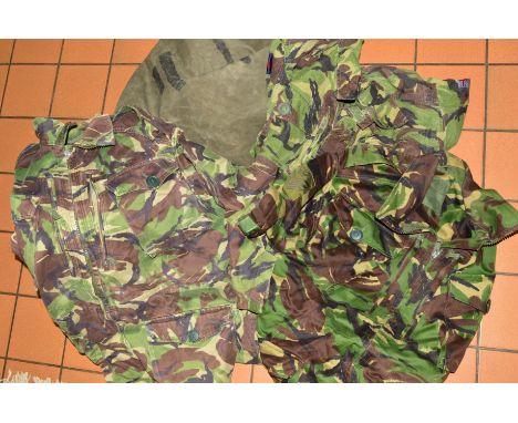 A GREEN CANVAS ARMY ISSUE BAG, containing four pairs of camo trousers, combat NATO DPM and four combat smock jackets NATO DPM