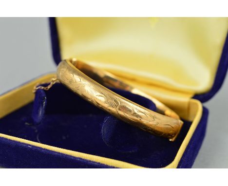 A 9CT GOLD  MID TWENTIETH CENTURY OVAL HINGED BANGLE, half engraved to one side, hallmarked 9ct gold, Birmingham 1969, approx