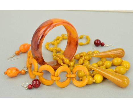 A SELECTION OF PLASTIC JEWELLERY to include a circular disc bracelet in dark yellow bakelite, a long graduated bead necklace 