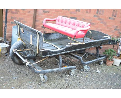 A VINTAGE TROIKA SLEIGH with red buttoned seat on large casters, approximate width 83cm x depth 210cm x height 115cm