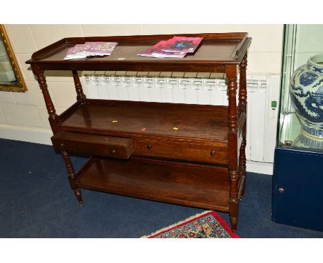 AN EDWARDIAN MAHOGANY THREE TIER BUFFET, the top shelf with a gallery above two drawers joined by turned supports on brass ca