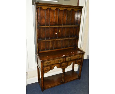 A NARROW TITCHMARSH AND GOODWIN OAK DRESSER the upper section with a two tier plate rack above a base section with three shor