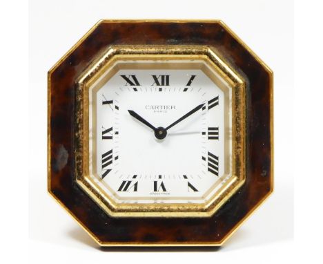 An octagonal easel alarm clock by Cartier of Paris, gilded brass with faux tortoiseshell surround, signed dial, applied roman