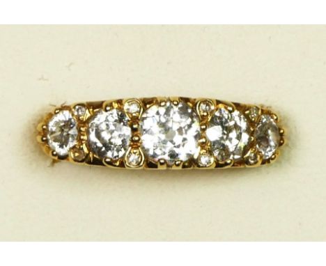 An 18ct gold five stone diamond ring, carved claw set with graduated old cut stones, diamond points between, approximately 0.