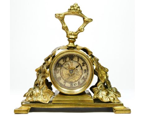 The British United Clock Co. Ltd., an early 20th century brass desk time piece, the dial with a day dreaming child, the case 