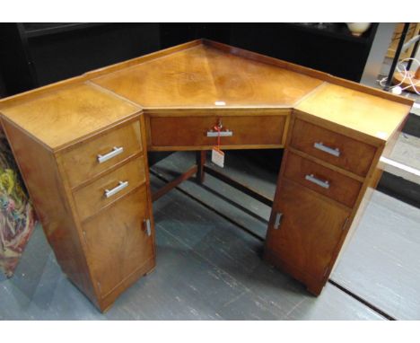 A HEALS WALNUT VENEERED CORNER DESK,  fitted with central drawer flanked by pedestals with two drawers over cupboards with ch