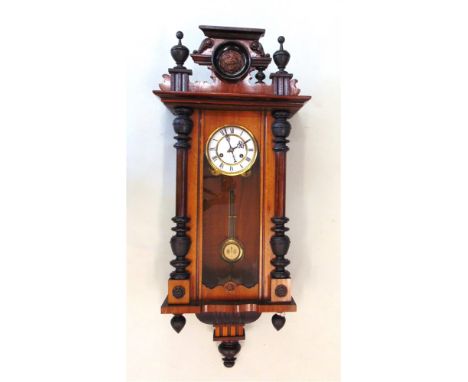 A CONTINENTAL WALNUT CASED WALL CLOCK,  with spring driven movement, 5' enamel dial with Roman numerals, 99cm high