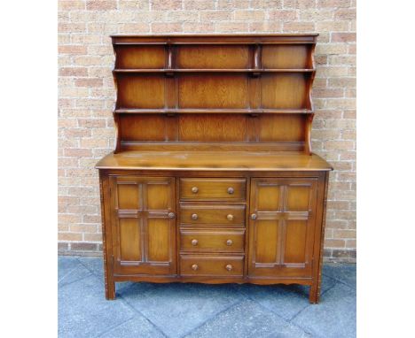 AN ERCOL DRESSER, the base fitted with four drawers flanked by cupboards, 146cm wide 52cm deep 170cm high