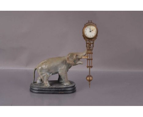 An early 20th century "Mystery Clock", modelled an an Elephant mounted on wooden base with the clock supported on it's trunk.