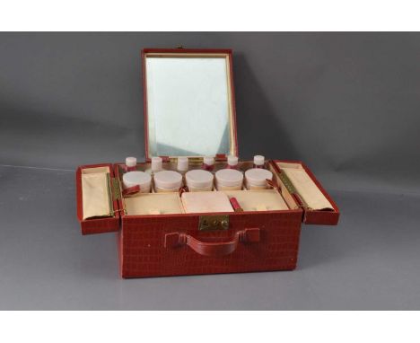 An original 1950s Elizabeth Arden red leatherette fitted vanity case, Including six 'Ardena' bottes, five pots and a lipstick
