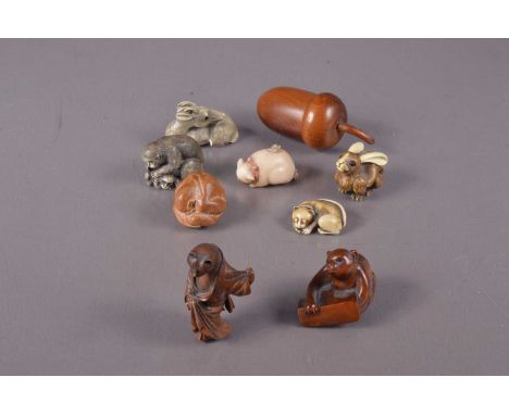 A signed hand-carved boxwood netsuke of a bat on a ledge, together with a boxwood netsuke of a cat wearing a kimono and geta.