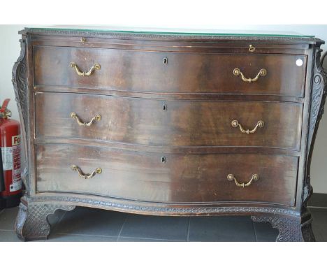 A George III Chippendale style dark mahogany bow fronted commode, three long drawers with a brushing slide above all with lac