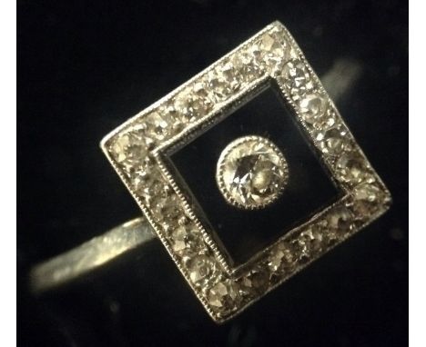 An Art Deco diamond and onyx panel ring, square black onyx panel set with a single central round brilliant cut diamond, surro