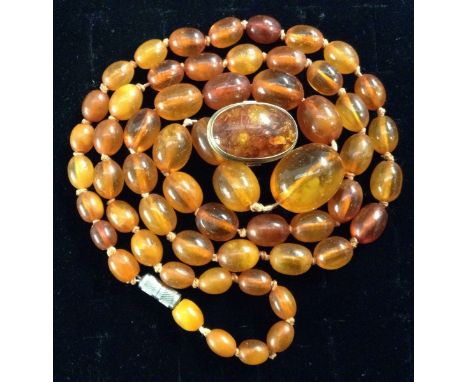 A graduating single strand amber bead necklace, individually knotted light and deep orange beads, barrel clasp, 70cm long;  a