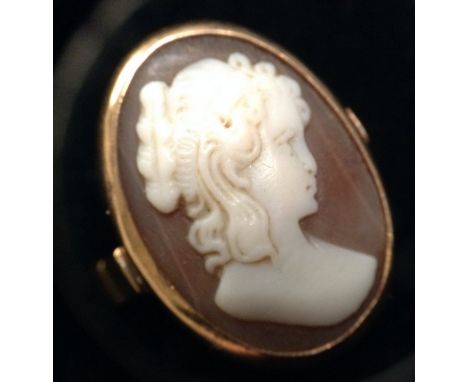 A 19th century oval carved shell cameo ring, portrait of a maiden facing right, unmarked rose coloured metal mount and shank,