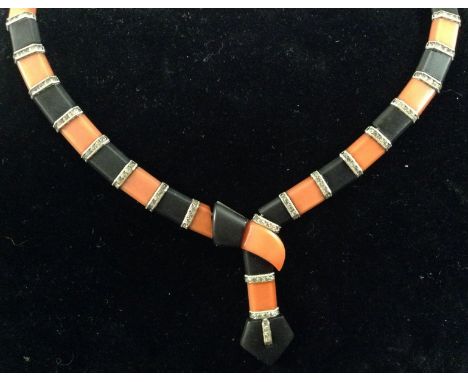 An Art Deco amber and black panel belt necklace, alternating amber and black panels each separated by a four stone paste and 