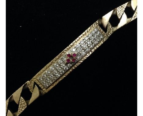 A 9ct gold paste panel bracelet, central rectangular panel encrusted with red and white paste stones, textured body and links