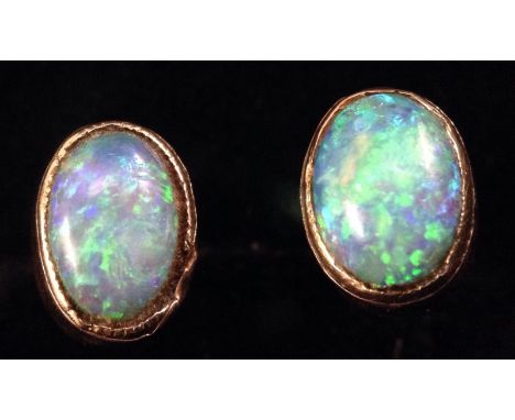 A pair of oval opal ear studs, each flashing green, blue and orange colour play, 9ct gold mounts and pillars, 7mm x 5mm, 1g g