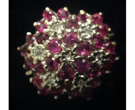 A ruby and diamond seven panel flower head cluster ring, 9ct gold shank, size K, 4g gross